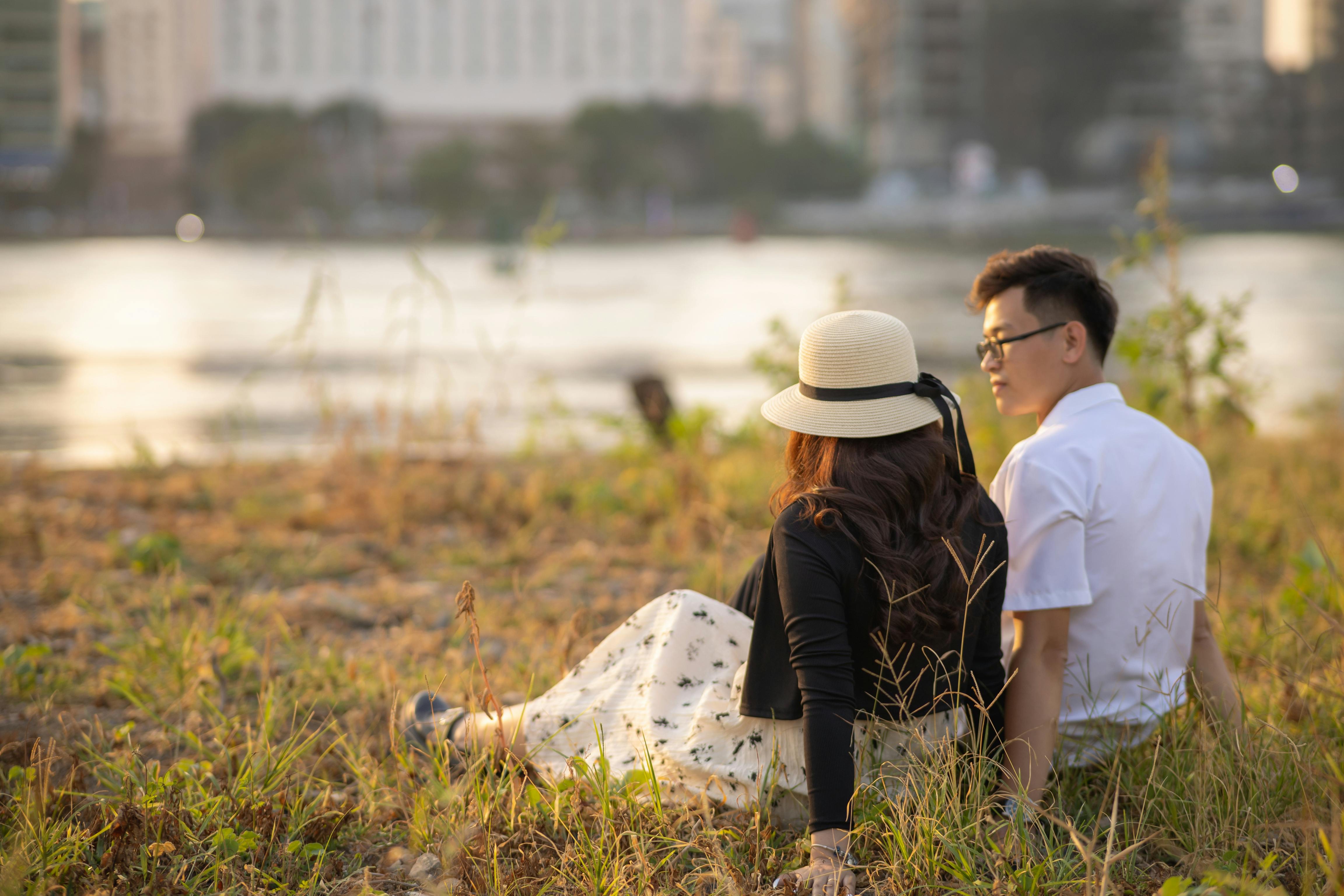 Two people sitting close together on the grass